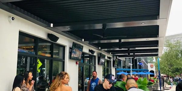 People having food under Louvered Roof