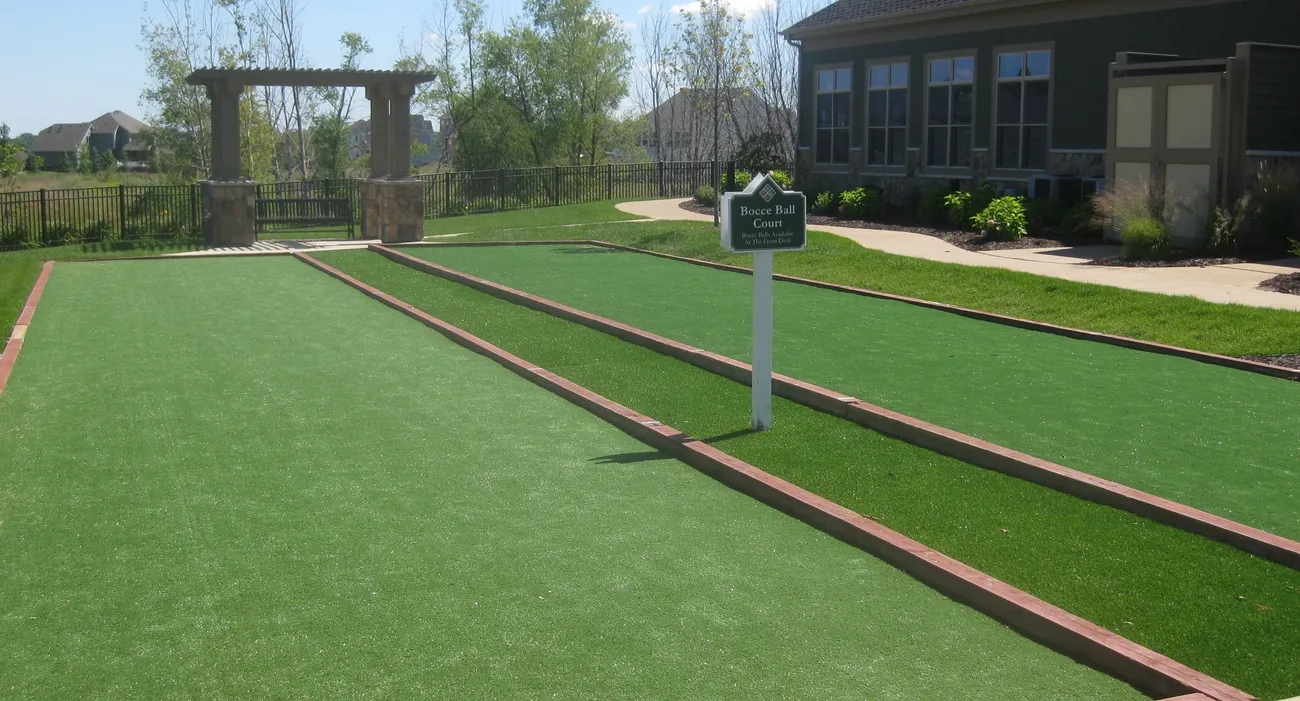 A Green Color Lawn With Pathway and Board